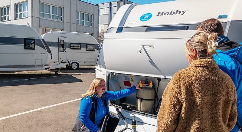 Beratungsgespräch auf dem Ausstellungshof von Caravaning Center Schmidtmeier zwischen einer Verkaufsberaterin und einem interessierten Kundenpärchen an einem Hobby Wohnwagen. Beratungsgespräch auf dem Ausstellungshof von Caravaning Center Schmidtmeier zwischen einer Verkaufsberaterin und einem interessierten Kundenpärchen an einem Hobby Wohnwagen.