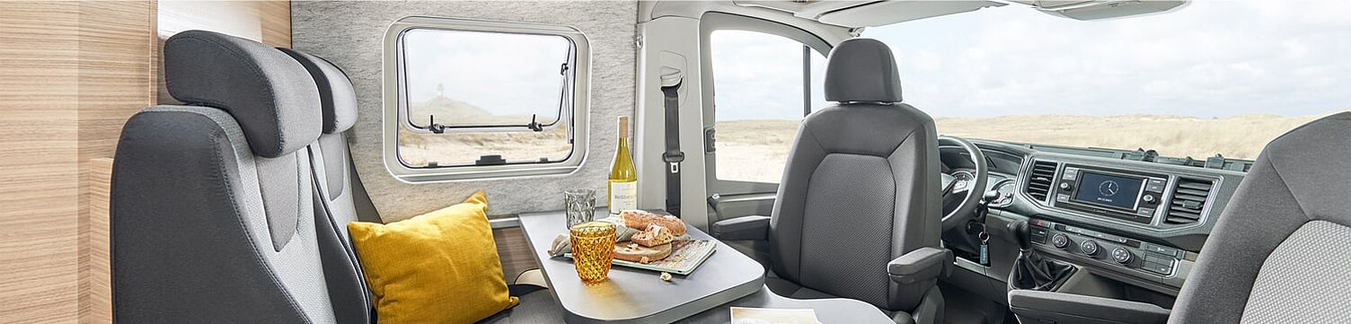 Innenansicht des Kastenwagens Hobby Maxia Van mit Blick in den Essbereich und das Cockpit.
