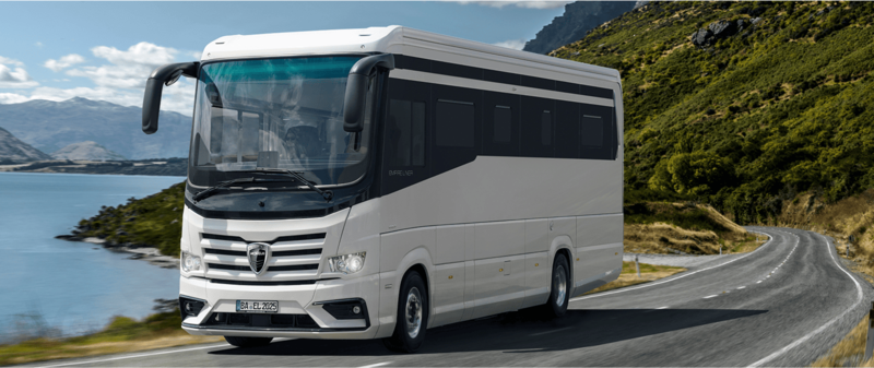 Außenansicht des Wohnmobils Morelo Empire Liner fahrend auf einer Landstraße vor einem Gebirgssee. Außenansicht des Wohnmobils Morelo Empire Liner fahrend auf einer Landstraße vor einem Gebirgssee.