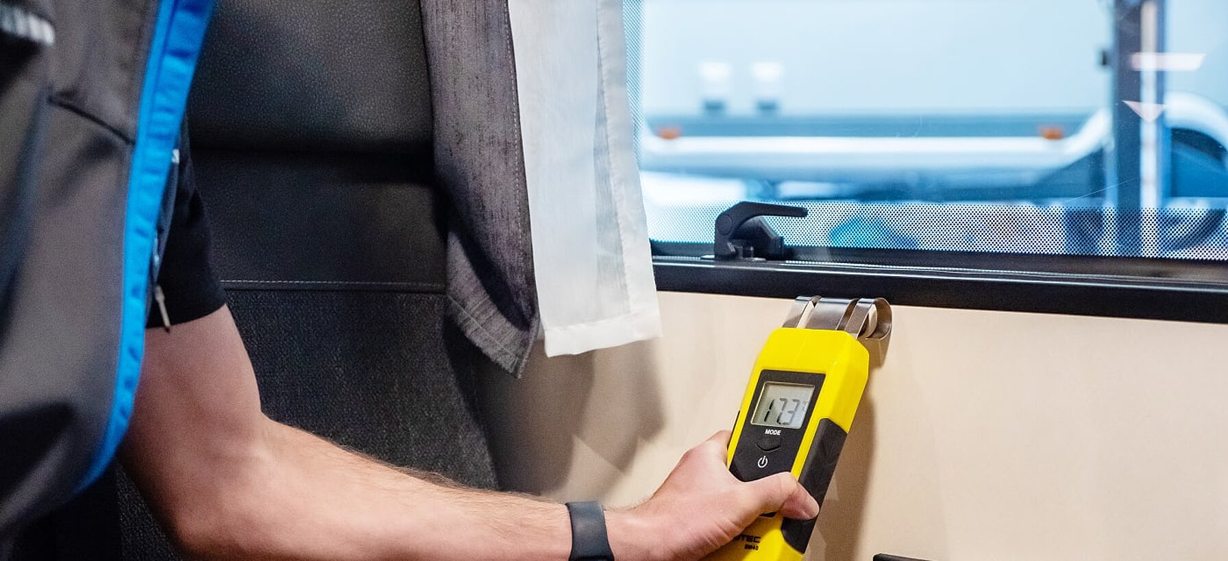 Werkstatt-Mitarbeiter von Caravaning Center Schmidtmeier bei der Durchführung eines Dichtigkeitstests mit einem Messgerät.