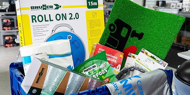 Gefüllter Einkaufskorb mit verschiedenen Zubehörartikeln aus dem Shop bei Caravaning Center Schmidtmeier.