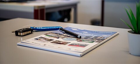 Fahrzeugschllüssel und Informationsbroschüre zum Thema Finanzierung von Caravaning Center Schmidtmeier