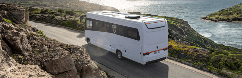 Außenansicht des Wohnmobils Morelo Loft Premium fahrend auf einer Küstenstraße mit Sicht auf das Meer. Außenansicht des Wohnmobils Morelo Loft Premium fahrend auf einer Küstenstraße mit Sicht auf das Meer.