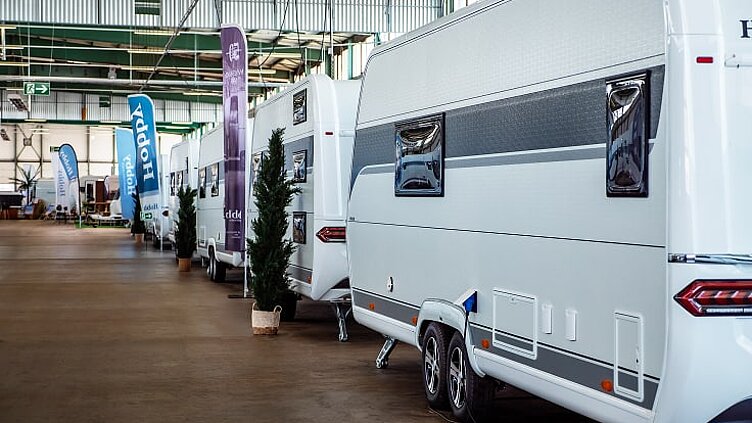 Blick auf verschiedene, weiße Hobby Wohnwagen in der Ausstellungshalle von Caravaning Center Schmidtmeier