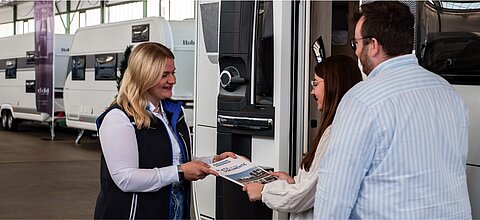 Beratungsgespräch zwischen einer Mitarbeiterin von Caravaning Center Schmidtmeier und einem interessierten Pärchen zum Thema Versicherung