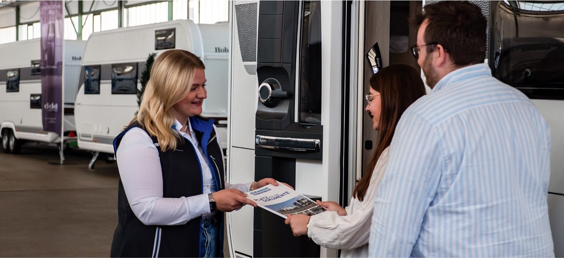 Beratungsgespräch zwischen einer Mitarbeiterin von Caravaning Center Schmidtmeier und einem interessierten Pärchen zum Thema Versicherung